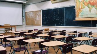 A classroom with desks and chalkboard.