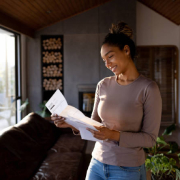 Smiling African American woman looks at a piece of mail.