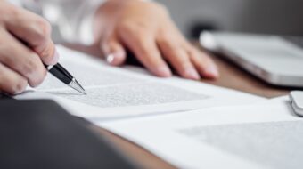 Someone reviewing a document with a pen.